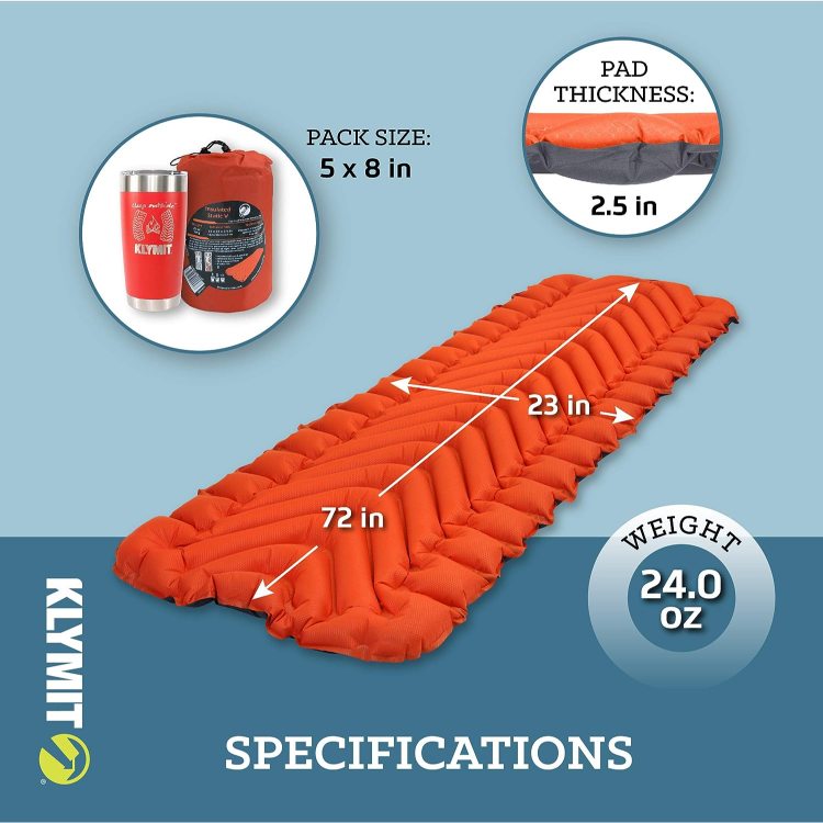 Red Klymit Static V inflatable sleeping pad with side rails and V-chamber design, inflated beside a campfire and camping gear on a starry night.