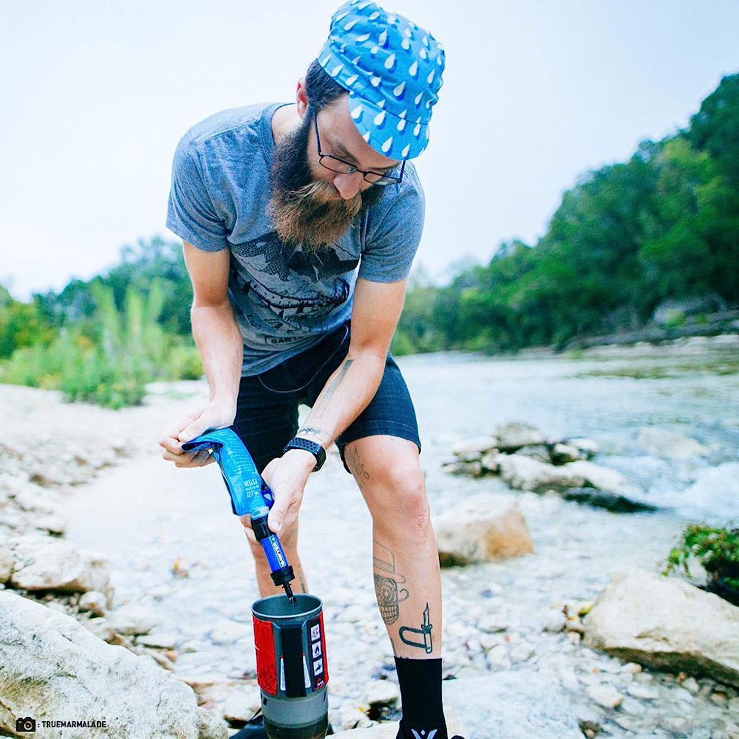 A person using a Portable Water Filter to purify water from a natural source.